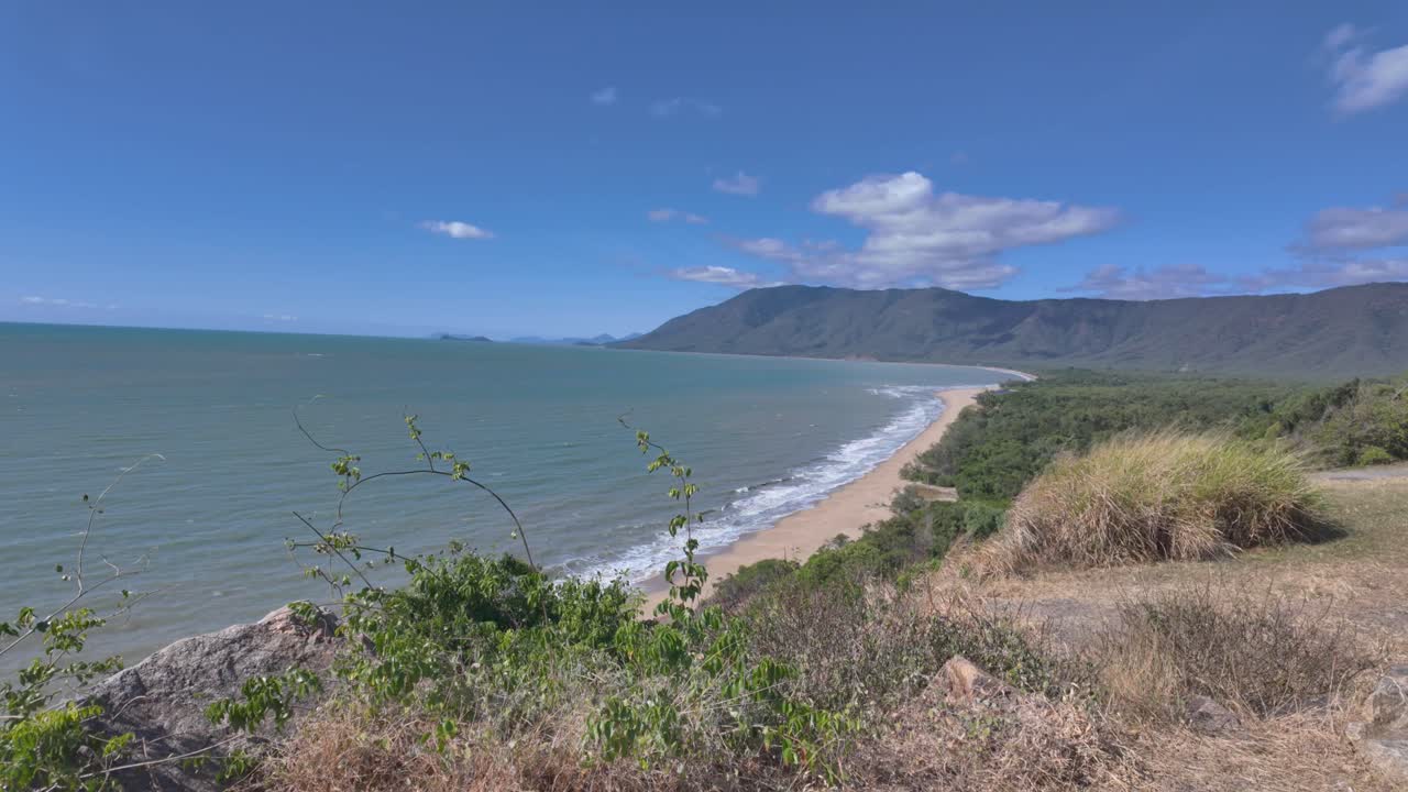 4K sweeping footage from a view point of a beautiful curved sandy beach in North Queensland in Australia
