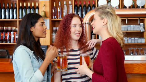 female friends interacting while having beer at counter 4k