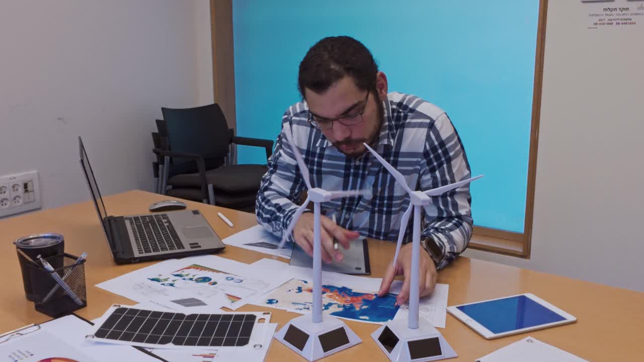 Focused Engineer Analyzing Data for a Sustainable Energy Report