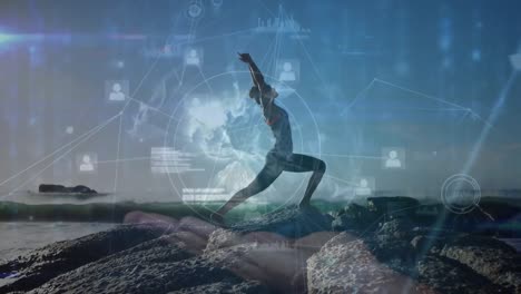 animation of digital globe and icons connecting with lines over woman meditating on rocky beach