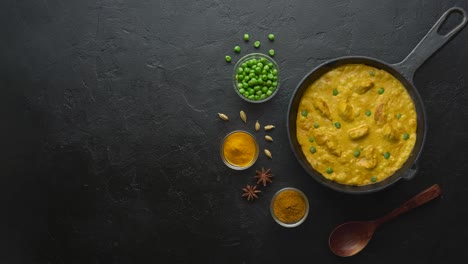 cinemagraph loop. cooking tasty chicken curry in pan with spices. flat lay, top view with copy space