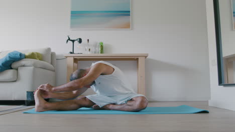 40 year old man does morning yoga to relieve back pain and stress