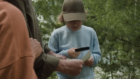 family map reading with magnifying glass outdoors