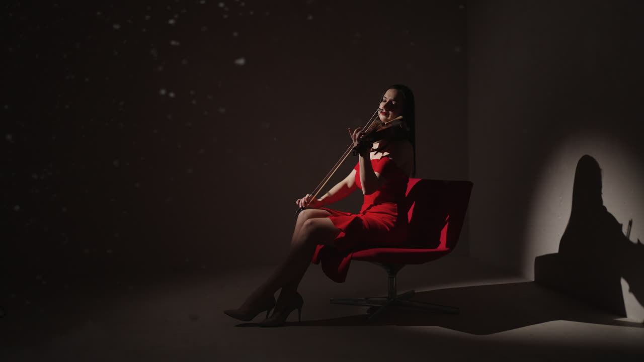 mujer tocando el violín en vestido rojo