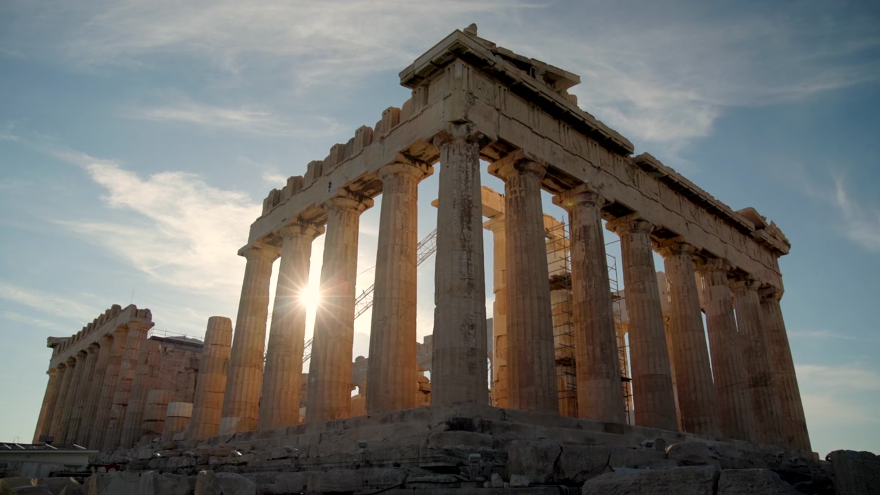 Calda luce serale che filtra tra le colonne storiche dell'Acropoli, creando una scena archeologica drammatica e iconica