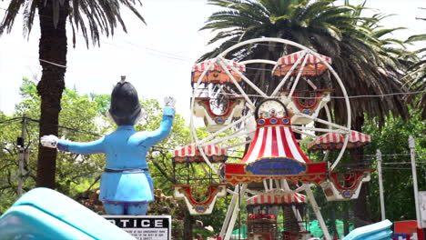 wide shot of a small merry go round in an empty amusement park