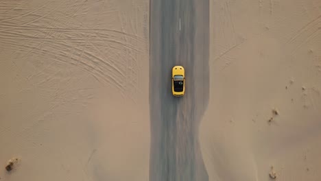 coche convertible amarillo en un camino del desierto