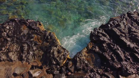 rocky volcanic coast in tenerife, canary island, with waves splashing, top down