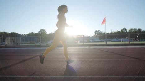 woman jogging on outdoor track in sportswear at athletic field