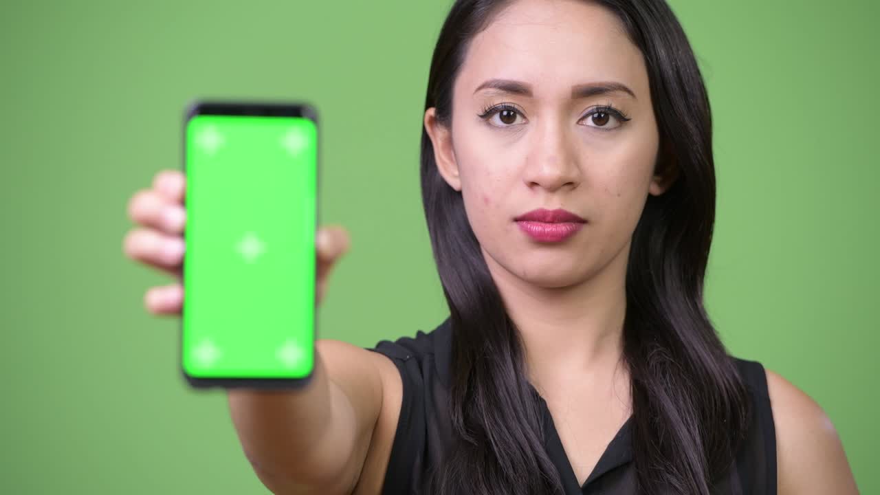 젊은 아름다운 아시아 사업가 여성이 전화를 보여주고 있습니다.