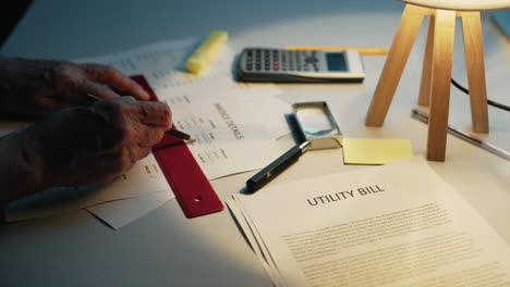 man calculates utility bills in his home