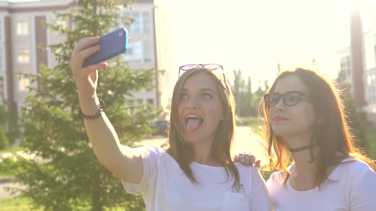 dos chicas tomando una selfie al aire libre