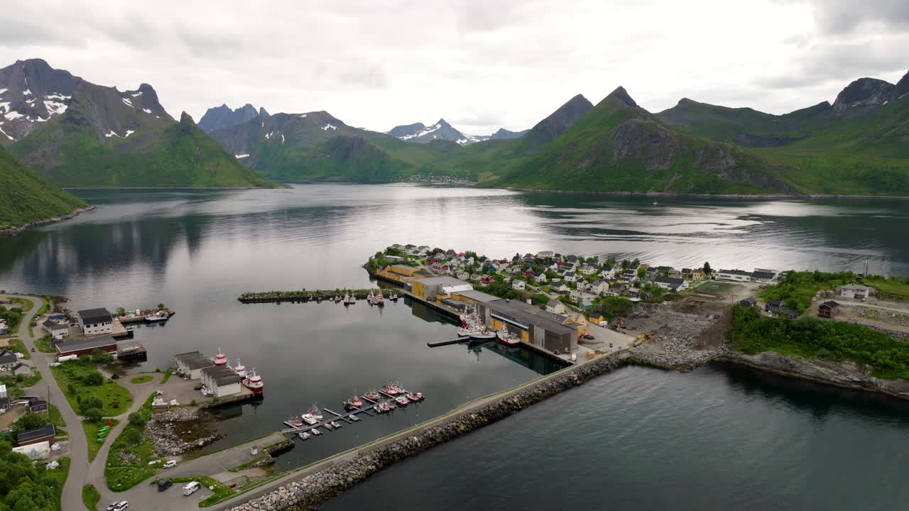 Husøy, remote fishing village on island in Øyfjorden, Senj, mountains and arctic landscape in northern Norway. Aerial drone view