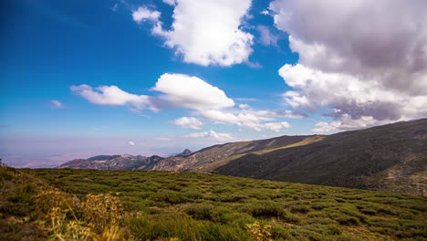 Zeitraffer-Von-üppigen-Grünen-Hügeln-Und-Flauschigen-Weißen-Wolken,-Die-über-Schatten-Fliegen