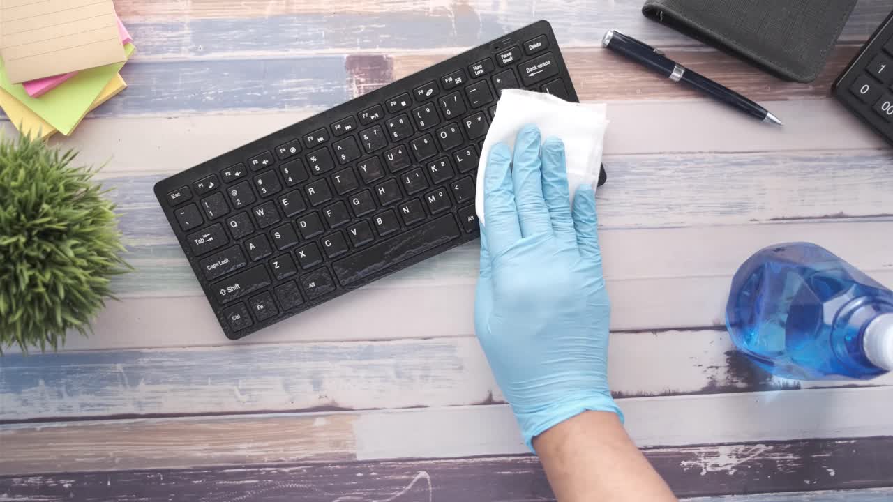 limpiando un teclado en un escritorio