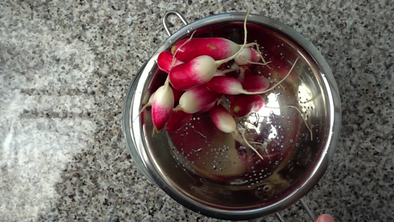 Tossing of a garden radish in a colander. Slow motion