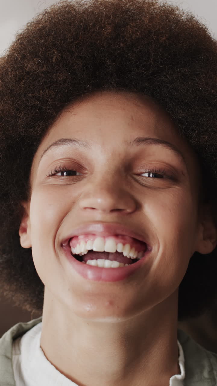Vertical video of portrait of happy biracial female worker in workshop in slow motion