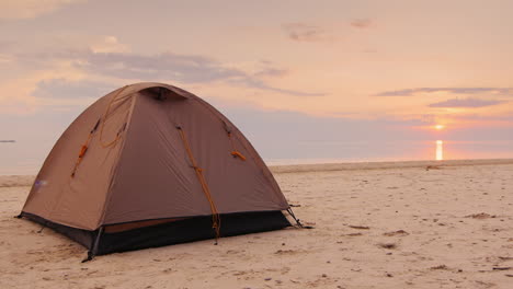 Das-Zelt-Ist-Im-Sand-Auf-Dem-Orangen-Meer-Und-Sonnenuntergangshintergrund