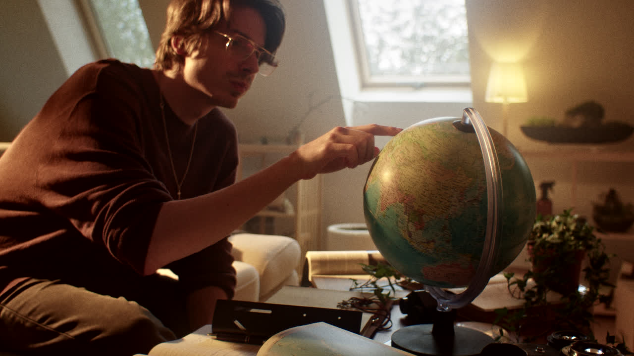 Young man studying and planning with a globe
