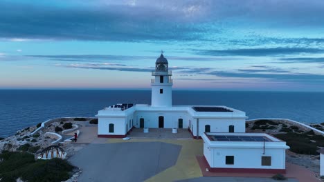 Drones-Aéreos-Se-Acercan-Al-Faro-De-Cavalleria-Torre-Arquitectónica-Paisaje-Marino,-Horizonte-Al-Atardecer-En-El-Norte-De-Menorca-Europa-España