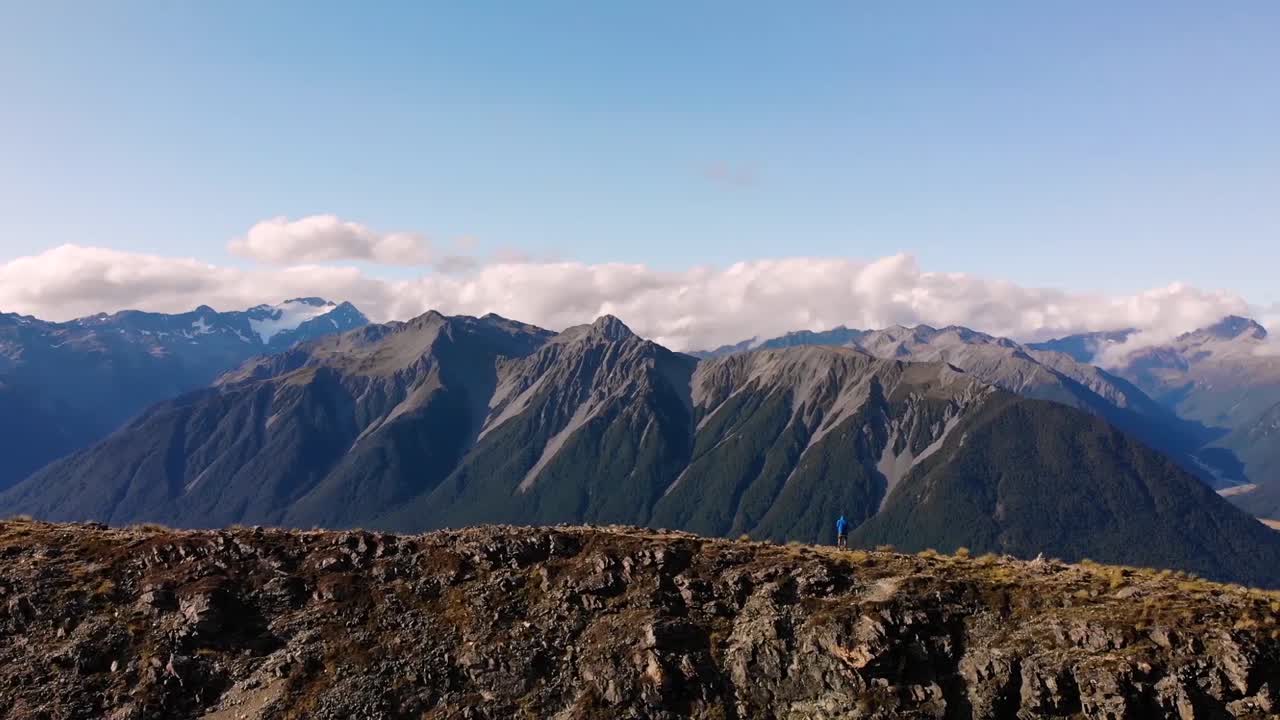 A Brave Man Standing On A High And Narrow Mountain Ridge In Southern Alps Of Arthur's Pass In New Zealand - Drone Shot Panning