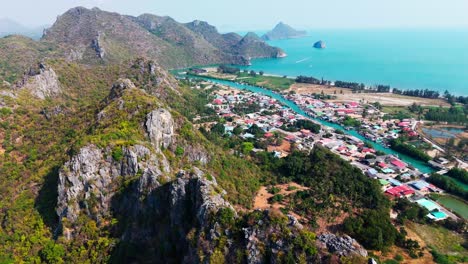 a breathtaking wide aerial view of khao sam roi yot national park, where lush landscapes meet the ocean, with a vibrant city on the beachfront. a stunning mix of nature and urban beauty in thailand.