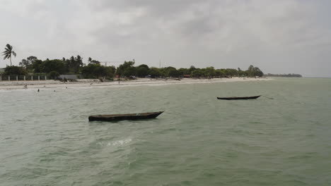 static shot of two wooden fishing canoe boats anchored near the beach side near dar es salaam, tanzania