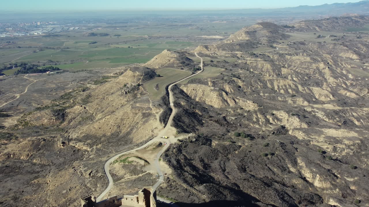 Aerial View of Ruined Castle in a Hilly Landscape