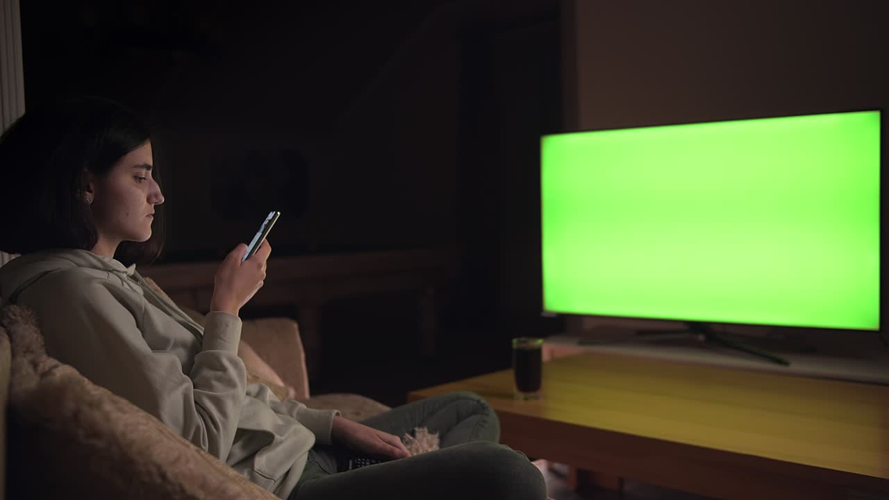 Ragazza seduta sul divano che guarda la TV e gioca ai giochi mobili, chroma key