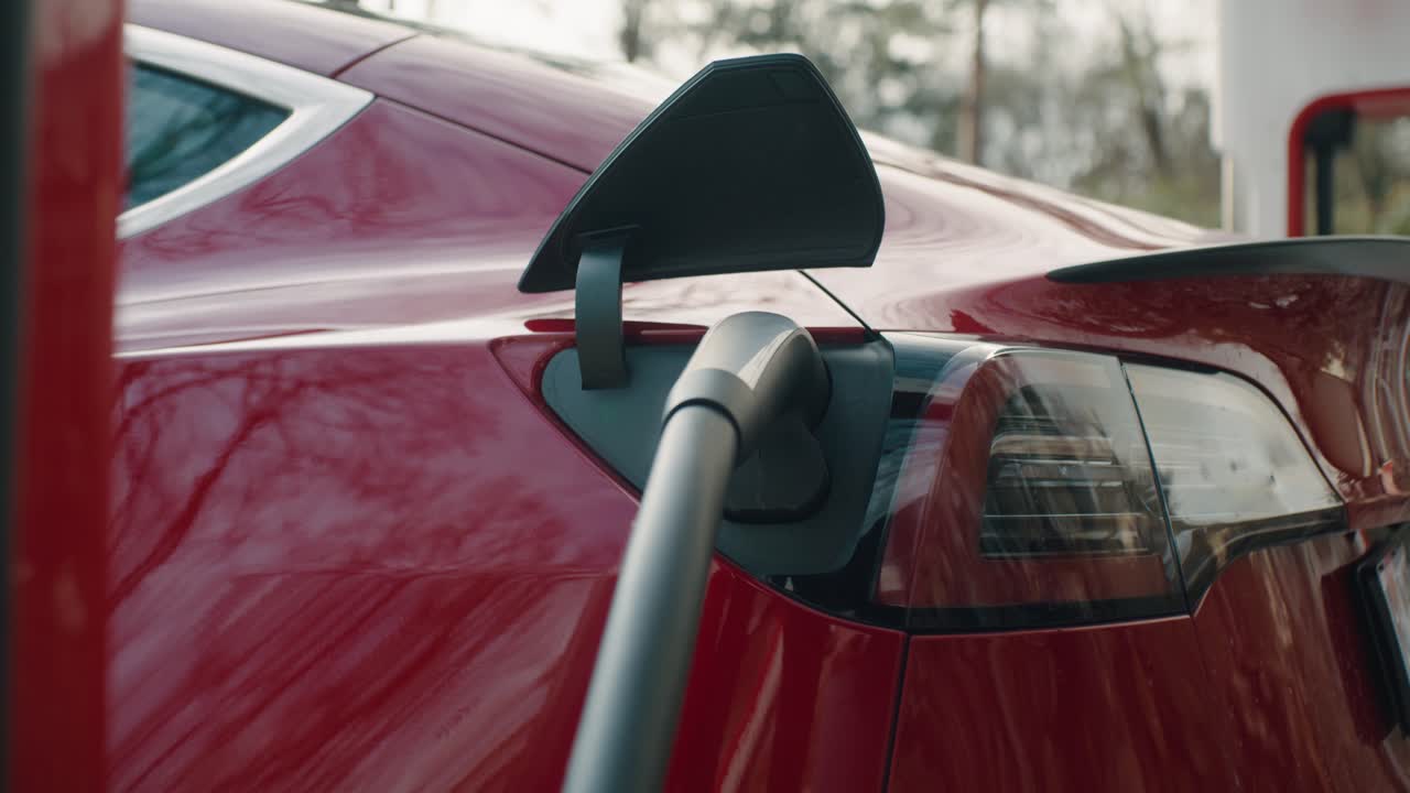 The electric car is being charged in the parking lot