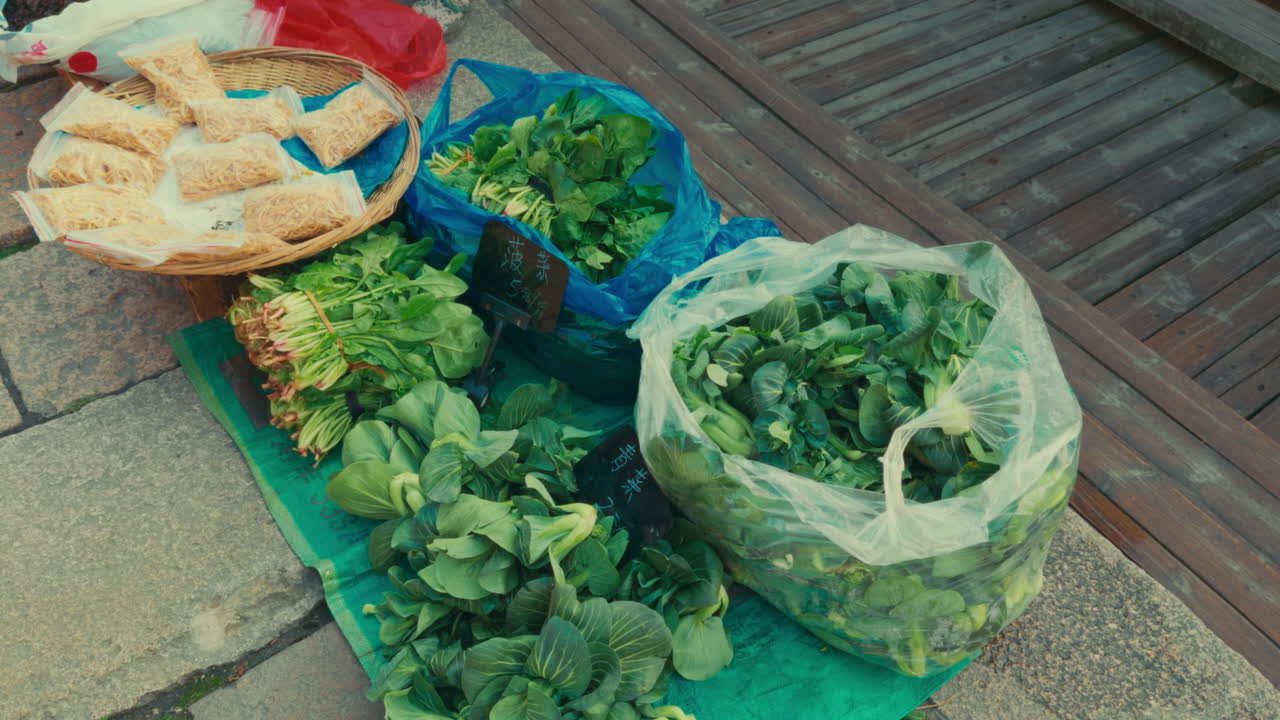 Fresh vegetables sold in Wuzhen market, with green leafy vegetables and snacks