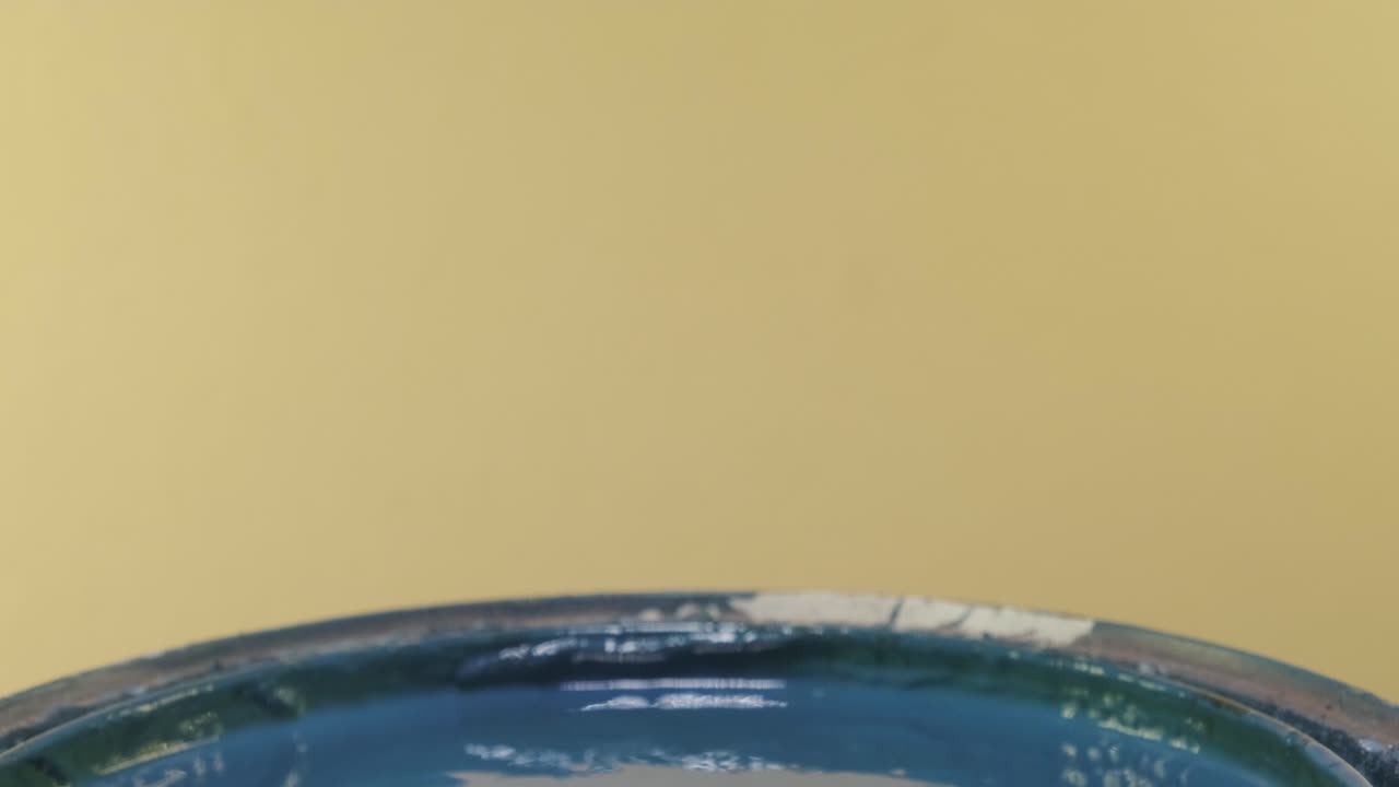 Close-up van PVC-buis gedompeld in blauwe verf.