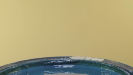 close up of pvc pipe dipped into blue paint