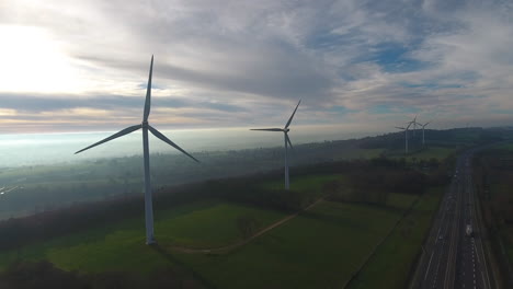 Windturbinen,-Elektrischer-Stromgenerator-In-Der-Nähe-Einer-Autobahn,-Nebliger-Morgen,-Luftdrohne