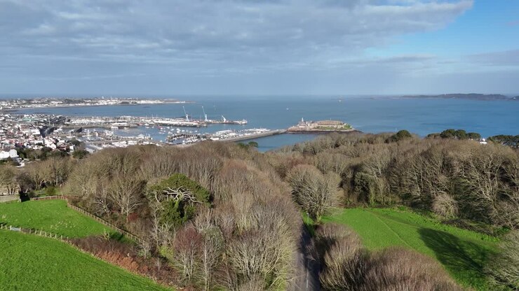 St Peter Port Guernsey flight from top of Vals de Terres over tree tops towards Castle Cornet with views over harbour, marinas, Belle Greve Bay and across to Herm
