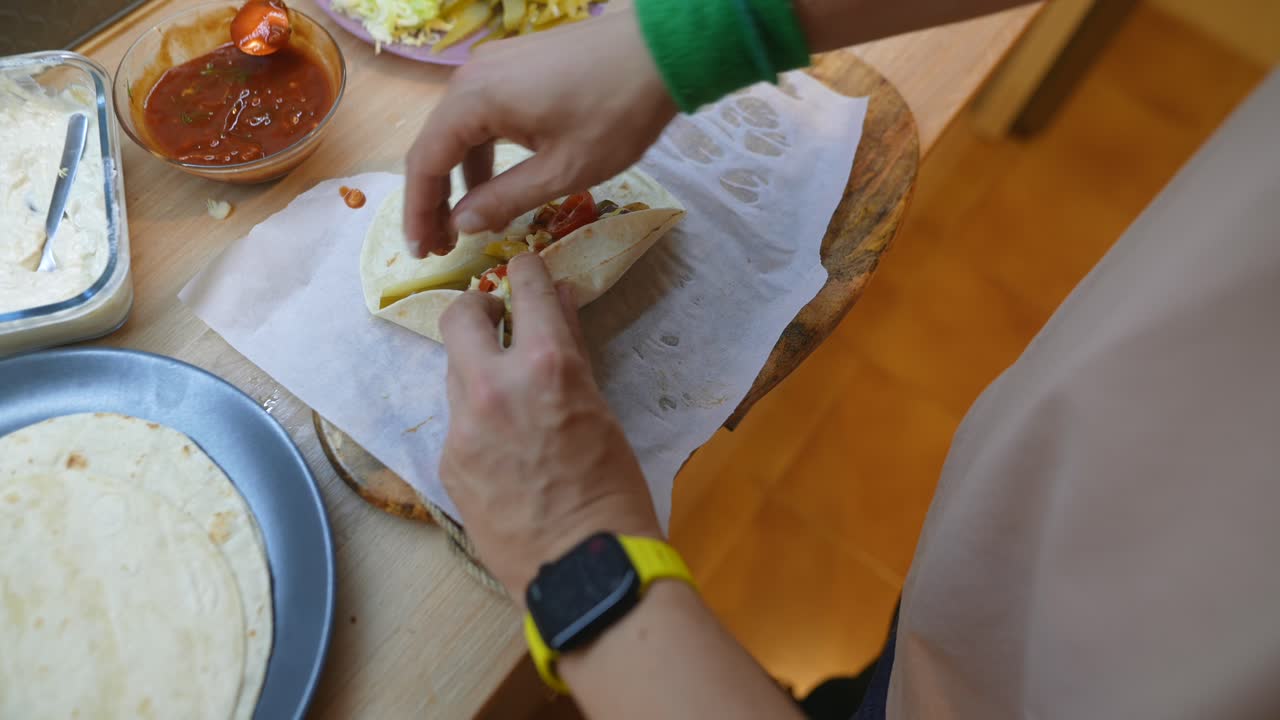 Close-Up of Hands Preparing a Delicious Burrito with Fresh Ingredients