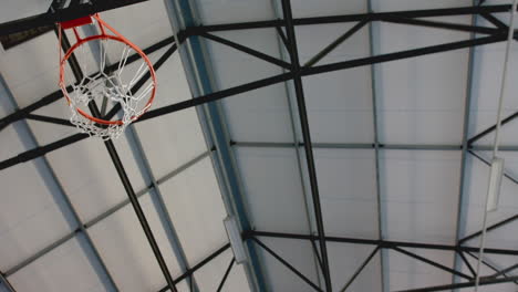 dunking basketball, athlete scoring in indoor court during game with intensity, copy space