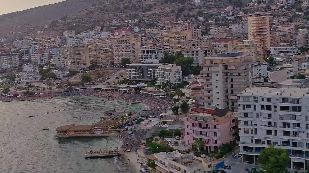 Vista costiera serale di edifici albanesi con montagne
