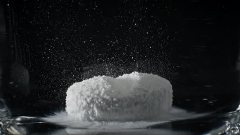 timelapse of white medicine pill capsule dissolving in water like a decomposing drug capsule in stomach and instestines