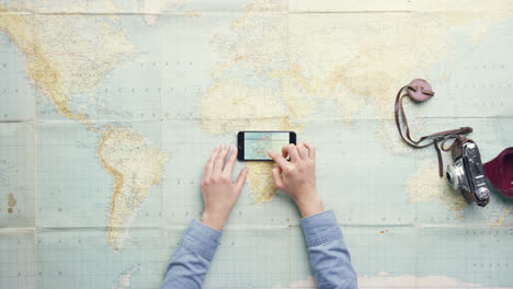 vista superior mujer viajera navegando mapa vintage del mundo manos planeando vacaciones en el escritorio desde arriba - dragón épico rojo