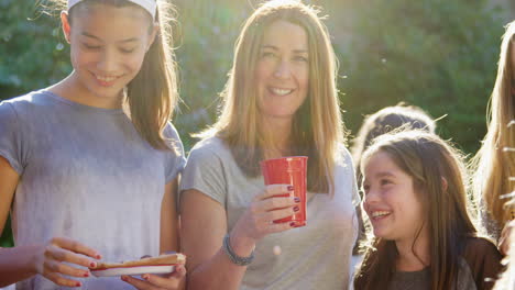 neighbours talk and eat at a block party, close up