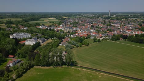 aerial drone shot of the idyllic municipality of thorn, maasgouw in limburg with a view of the beautiful green and flat landscape, the houses in dutch architecture and the church tower on a sunny day