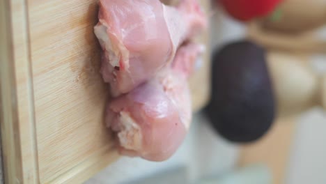 raw chicken drumsticks on a cutting board