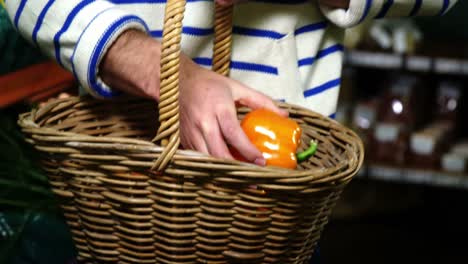 Mann-Mit-Körben,-Die-Paprika-Im-Bio-Bereich-Auswählen