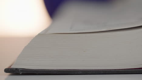 a woman turns with her fingers pages in a book