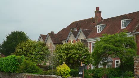 view of the historic mompesson house in salisbury, england, with red-brick facade, gabled rooftops, and lush garden surroundings in a traditional english setting.