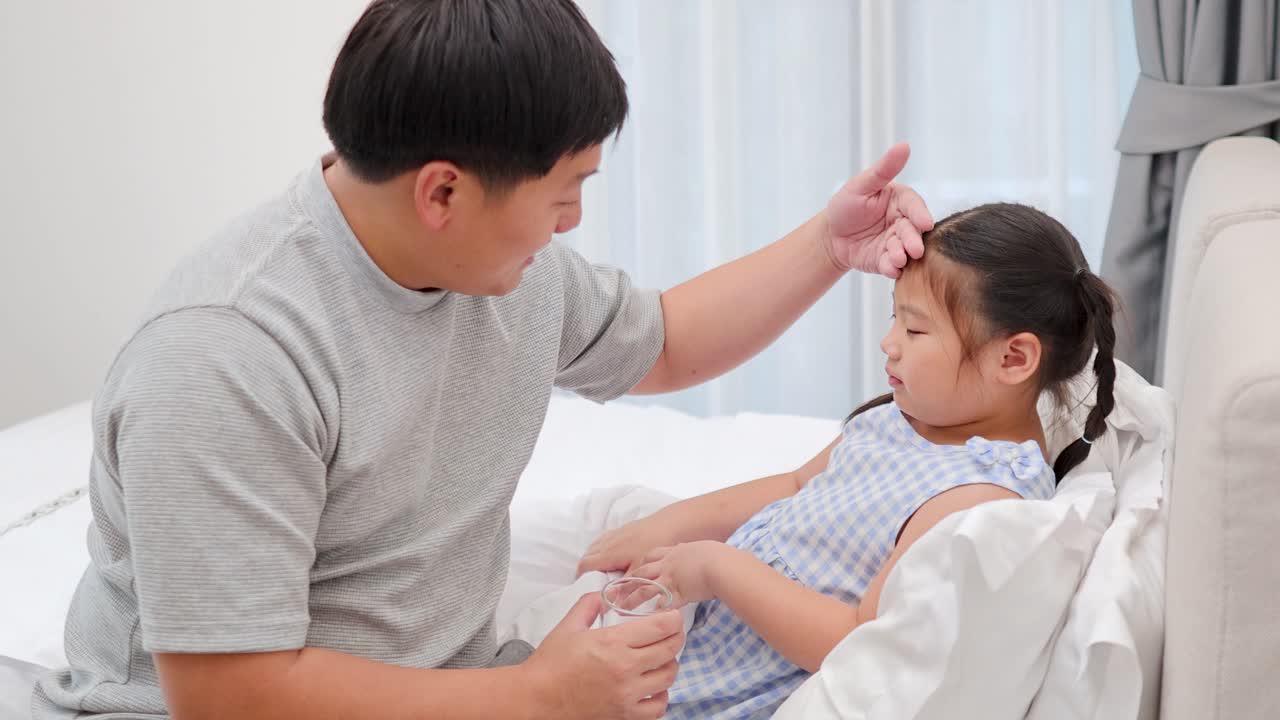 걱정하는 아버지가 아픈 딸을 침대에서 간호하며 체온을 확인하고 물을 건네는 모습, 부드러운 햇살