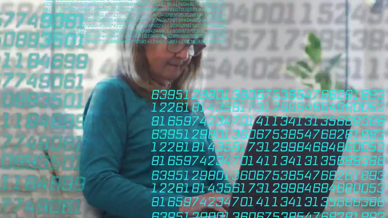 Mujer mayor tecleando en un portátil, iniciando una superposición de código numérico flotante turquesa mientras investiga tecnología.