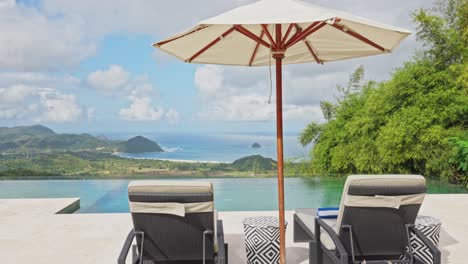 cinematic slide behind sun pool loungers next to infinity pool overlooking the ocean