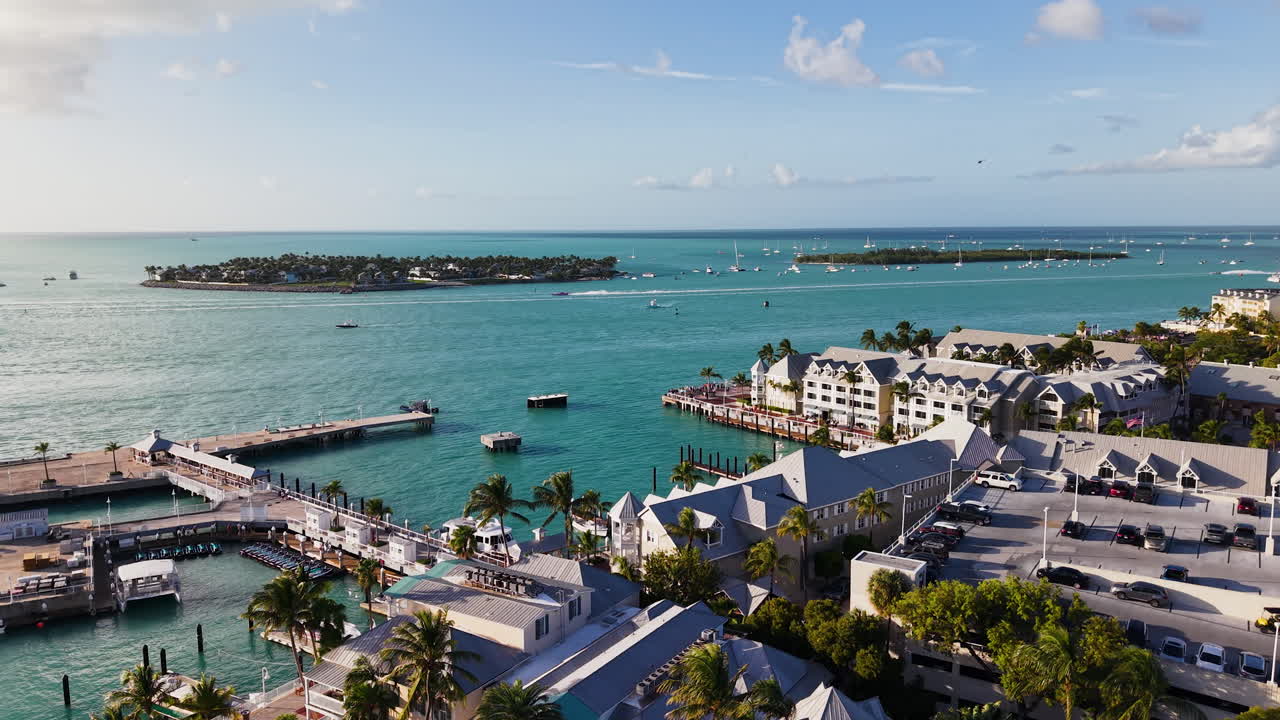 AERIAL: Boats race on the coastline of Key West, golden hour in Florida, USA